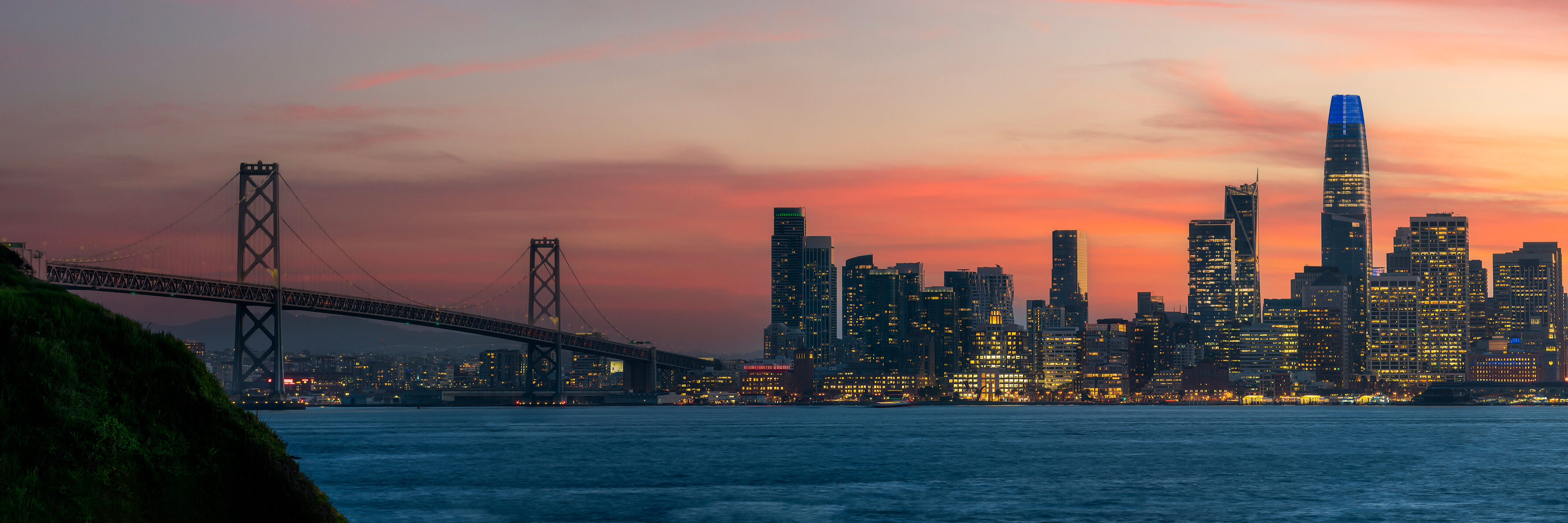 Cityscape view of San Francisco and the Bay Bridge with Colorful Sunset from island.