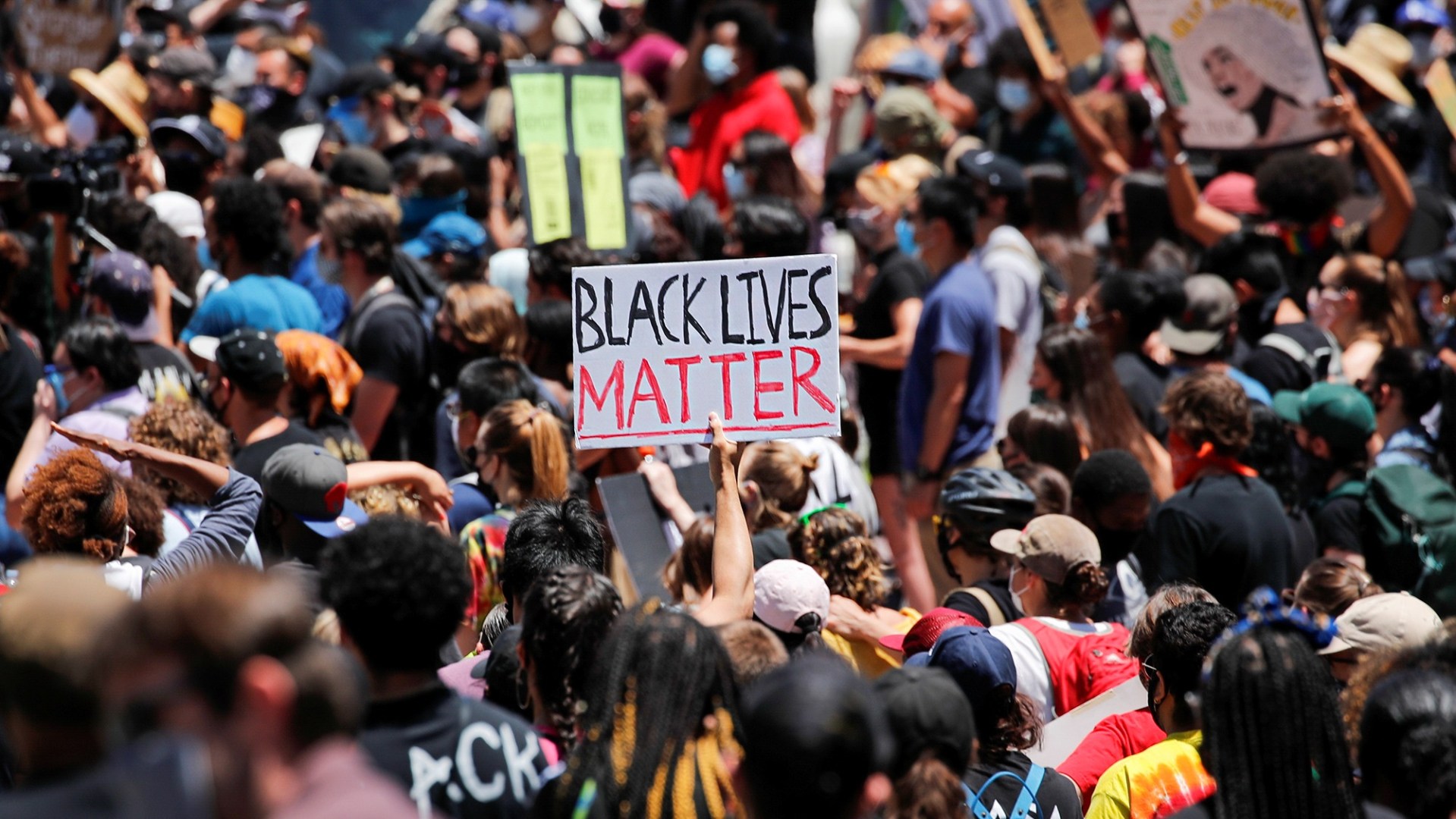 A crowd of protestors with a sign reading "Black Lives Matter"