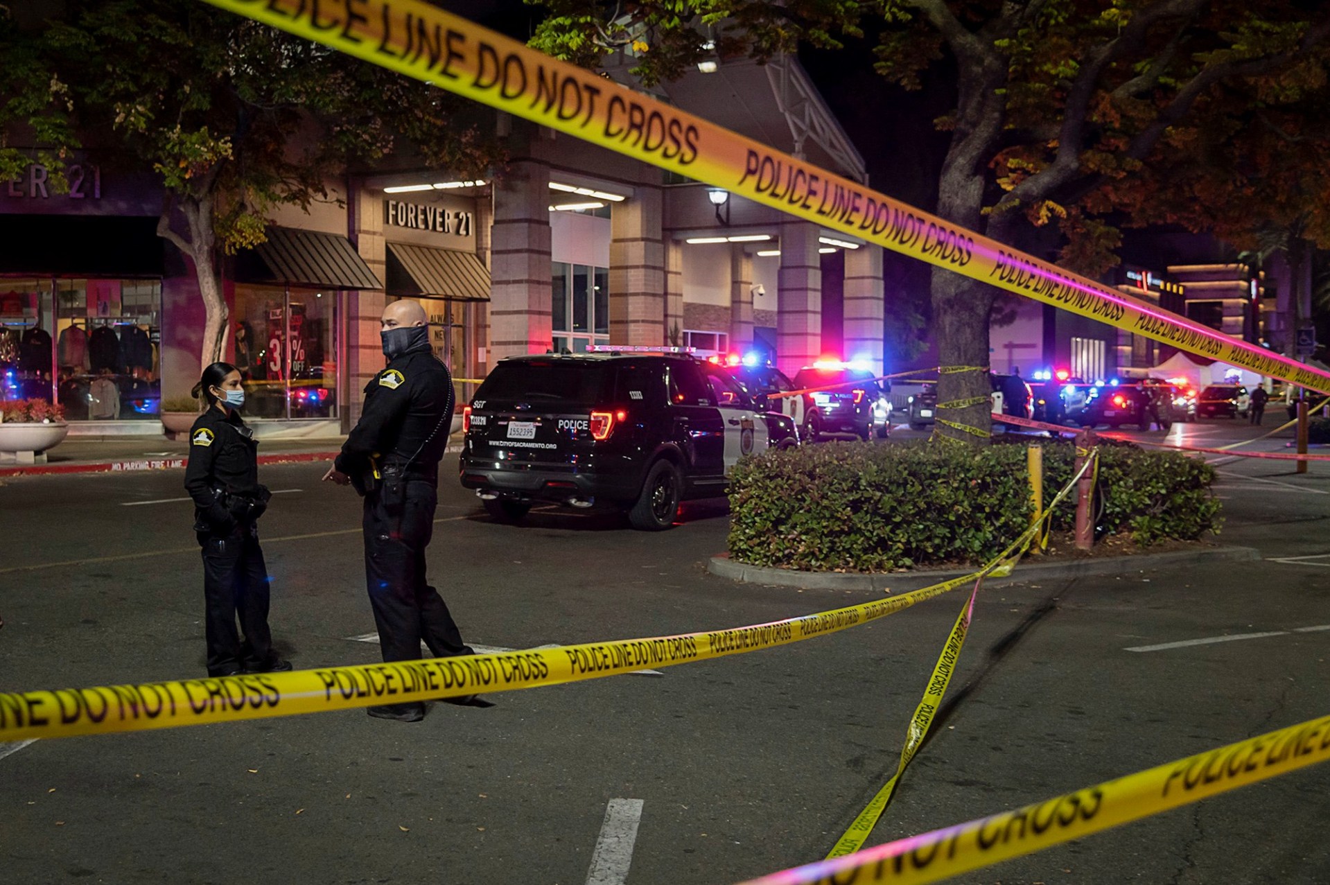Sacramento Police Department officers stand watch behind crime scene tape at Arden Fair mall after a shooting killed two people in Sacramento on Nov. 27, 2020. Paul Kitagaki Jr./Sacramento Bee via REUTERS