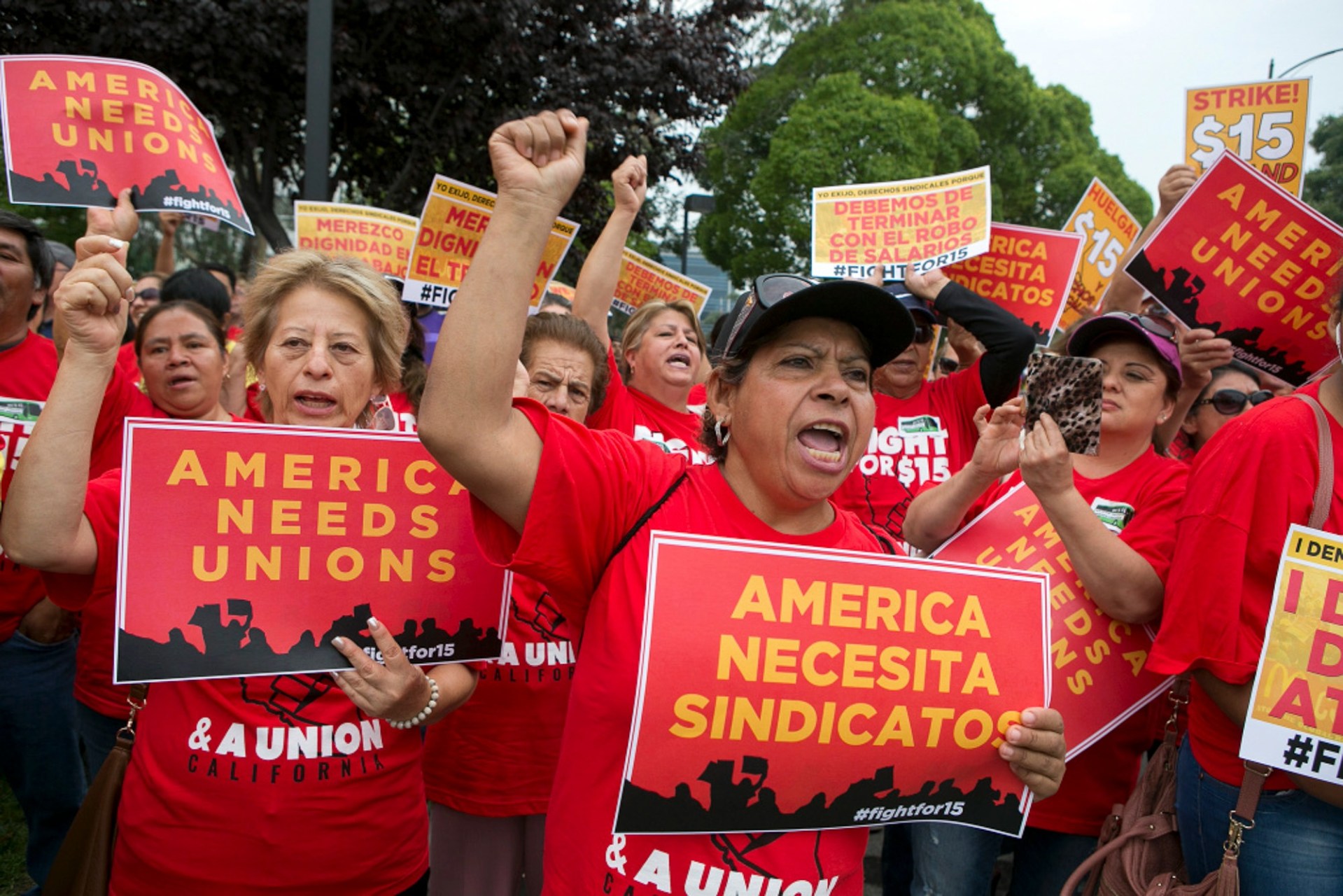 Josefina Pulido, center, cheers while holding a sign that read 'America needs unions' during a Service Employees International Union rally for higher wages at McDonald's in San Jose on September 4, 2017. Bay Area workers are joining the national 'Fight for $15' protest and are part of a nationwide union organized Labor Day action. Photo by LiPo Ching, Bay Area News Group